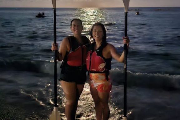 Dos participantes posando tras la ruta nocturna en kayak junto al mar