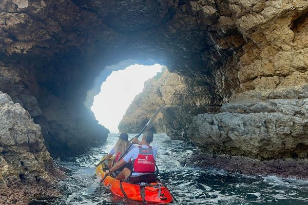 Pareja entrando en una cueva marina durante una ruta en kayak con Alicante Aventura