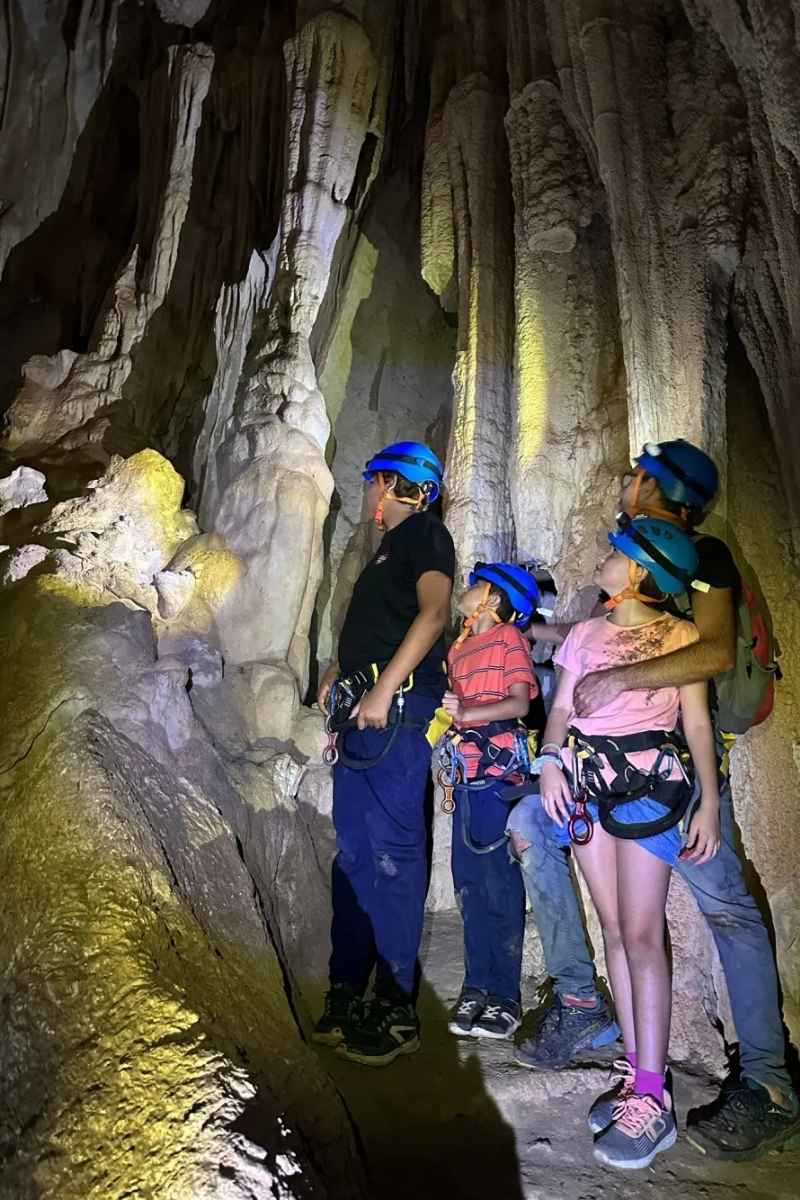 Grupo explorando las formaciones del interior de la Cova Fosca en Ondara
