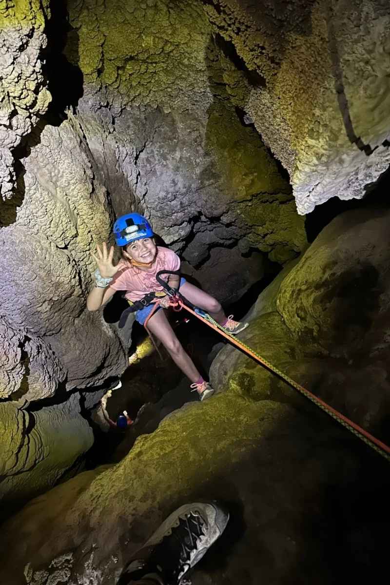 Participante realizando un rápel en el interior de la Cova Fosca en Ondara