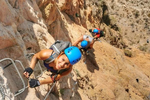 Grupo de participantes ascendiendo una pared equipada en una vía ferrata de Alicante