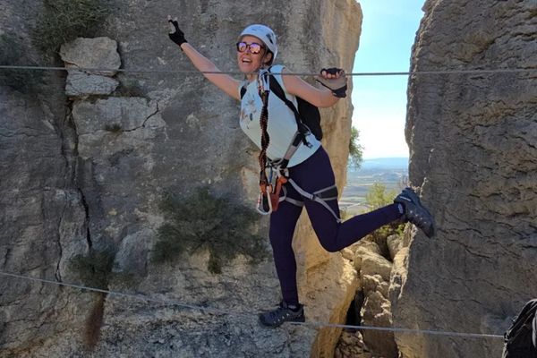 Participante cruzando un puente de cable durante una vía ferrata en Murcia