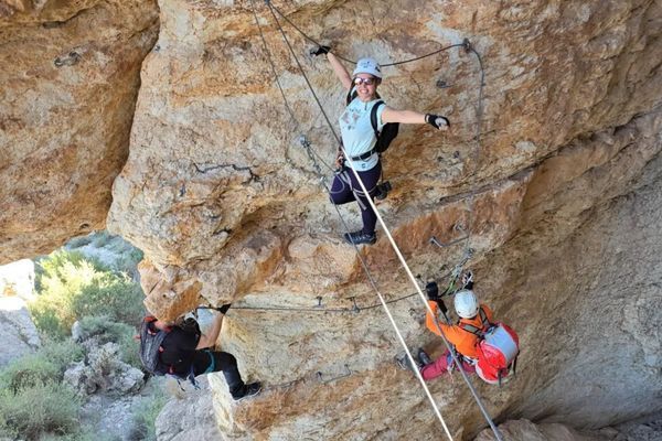 Grupo de participantes progresando por una pared equipada en una vía ferrata de Murcia