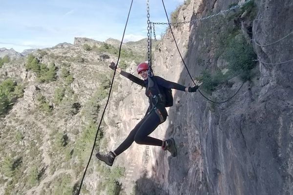 Participante superando un paso aéreo durante una vía ferrata en Valencia