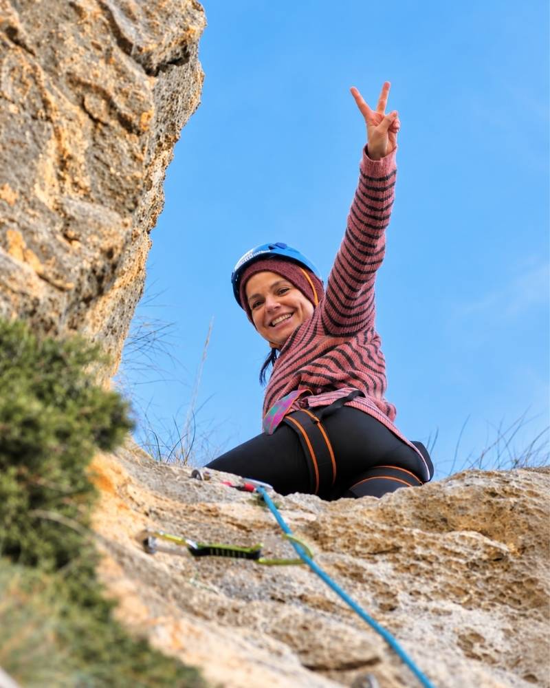 Participante celebrando su bautismo de escalada en Elda, Alicante, tras ascender una pared de roca