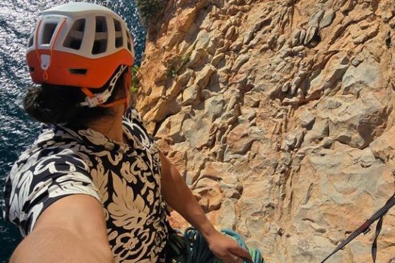 Participante con casco y cuerdas junto a una pared rocosa durante la escalada Magical Mystery Tour